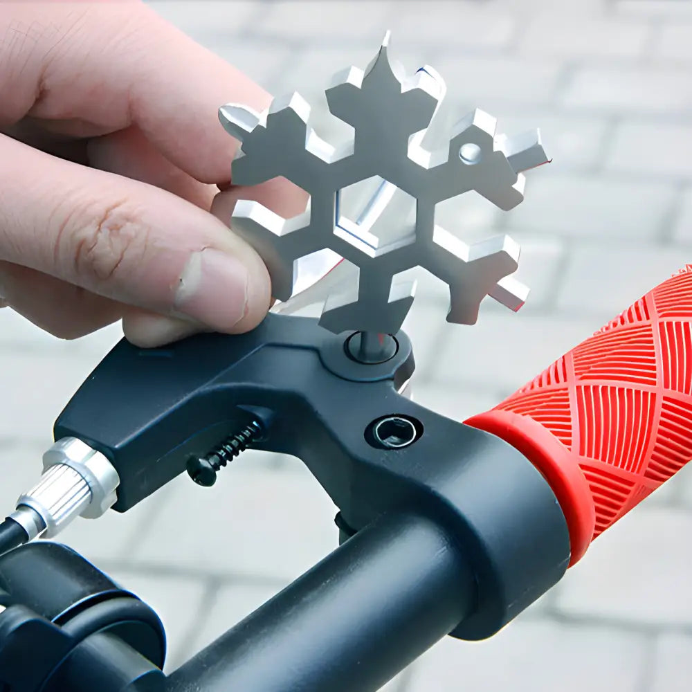 Snowflake-shaped multi-tool being held over a bicycle handlebar.