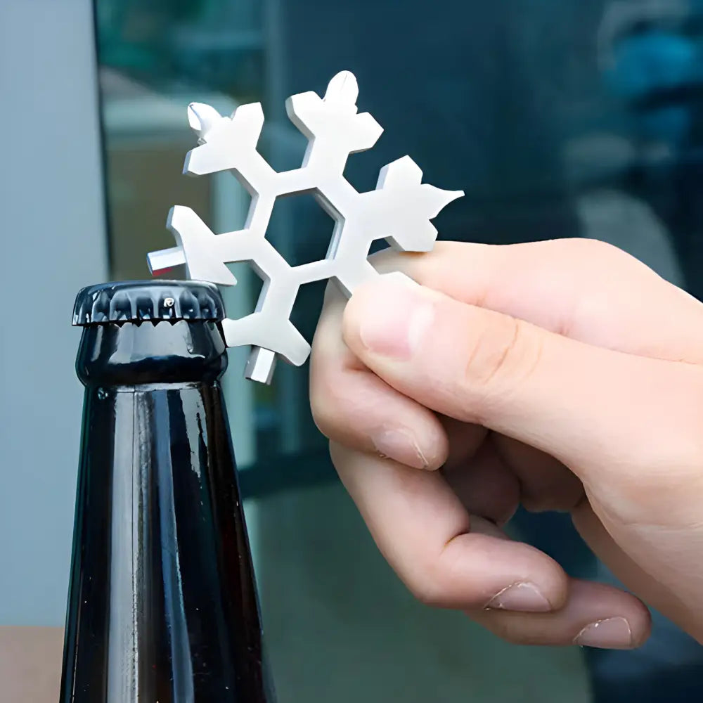 Snowflake-shaped bottle opener being used to open a dark glass bottle.