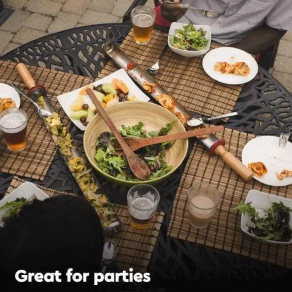 Outdoor dining table set with various dishes, salads, and beverages.