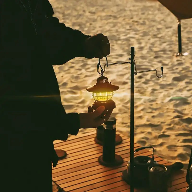 Glowing lantern being held over a wooden surface at dusk.