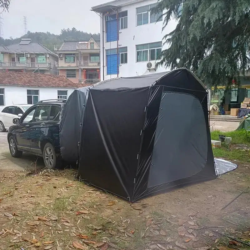 Black portable garage tent set up next to a parked car.