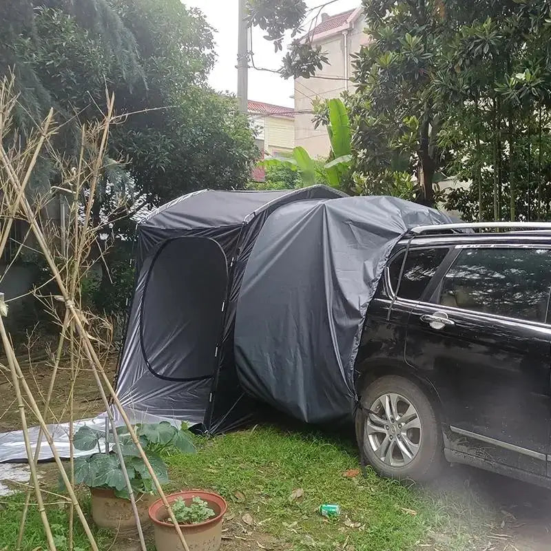 Dark gray tent-like structure attached to the side of a black vehicle.