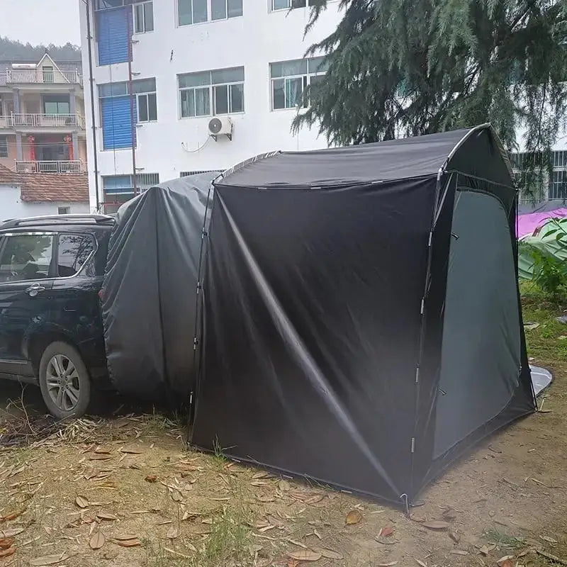 Portable garage tent attached to a parked vehicle.