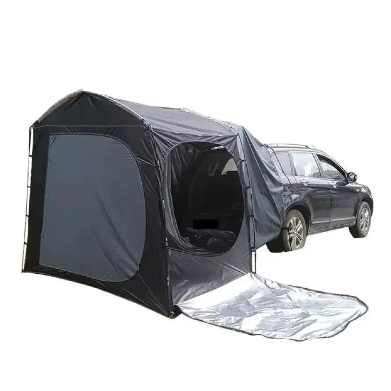 Tent-like attachment connected to the rear of an SUV for camping or outdoor activities.