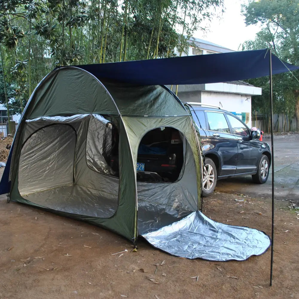 Camping tent attached to the side of a car, creating an extended shelter area.