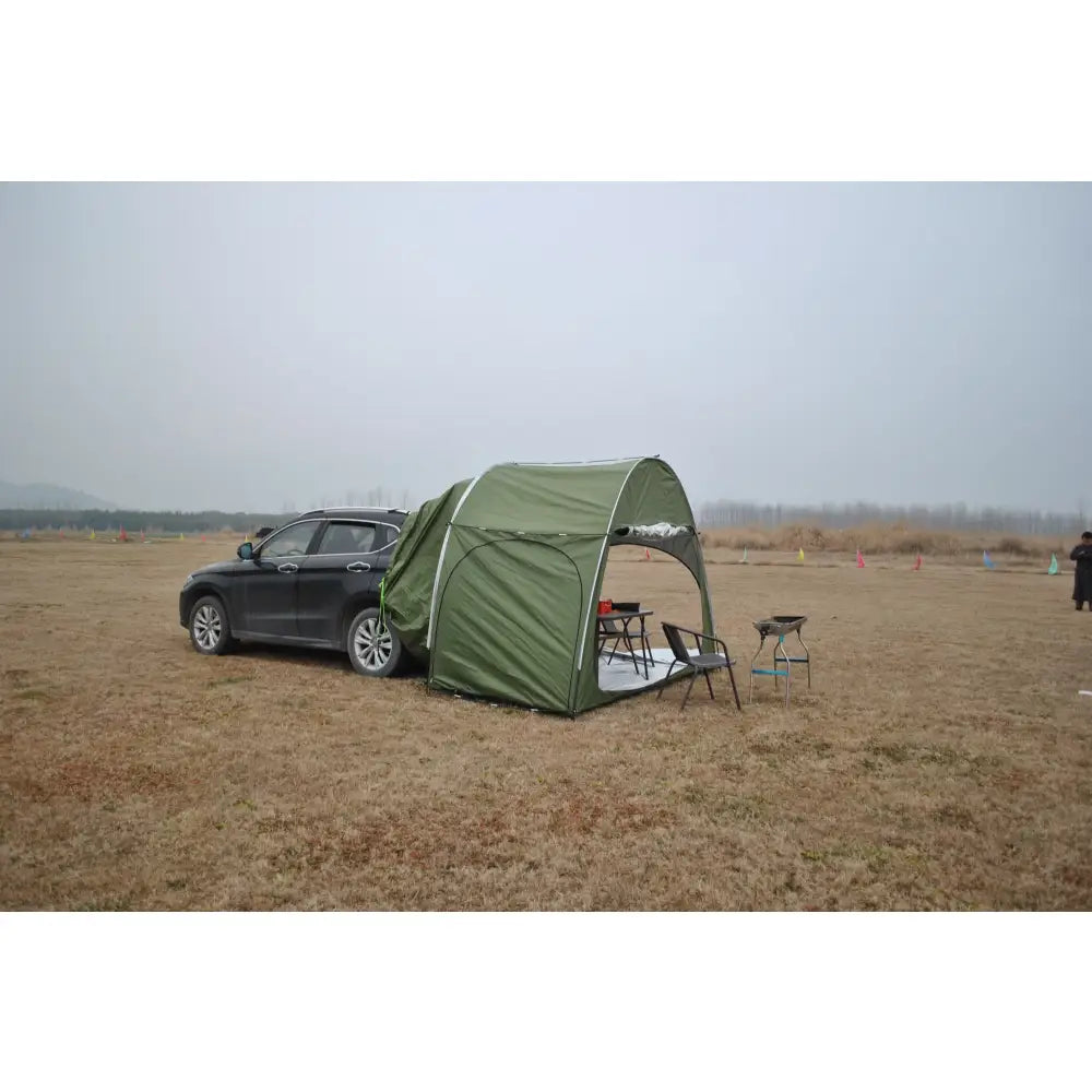 Car-attached tent setup in a field.