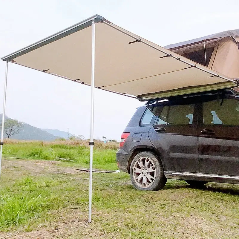 Vehicle-mounted awning extending from the side of an SUV.