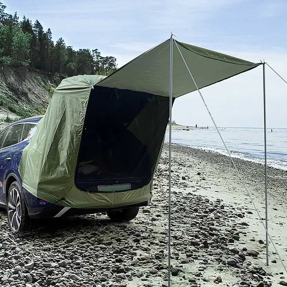 Car-mounted tent with an extended awning on a beach.