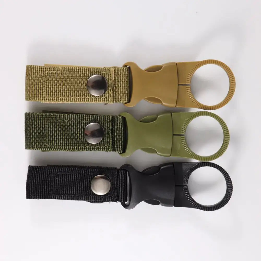 Tactical key rings or carabiners in tan, olive green, and black colors.