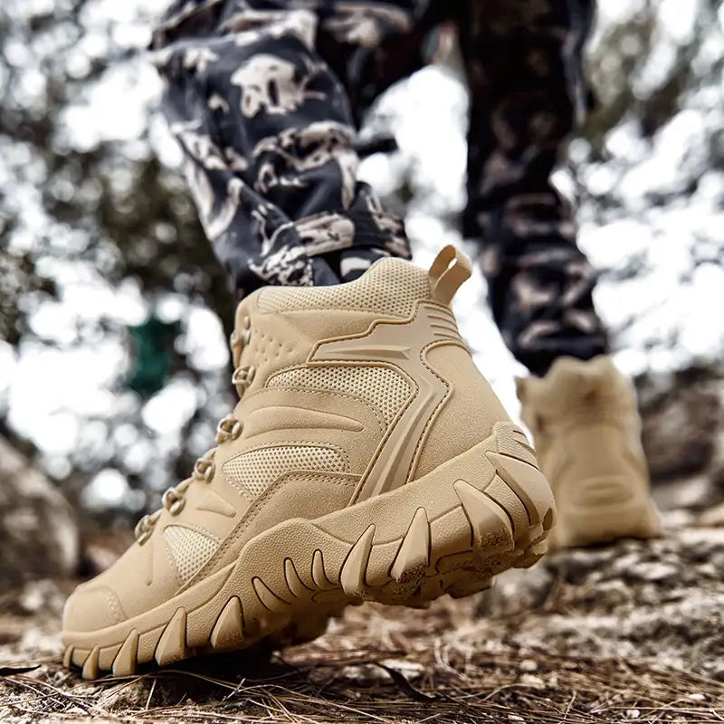 Tan tactical or hiking boot with rugged tread on rocky ground.