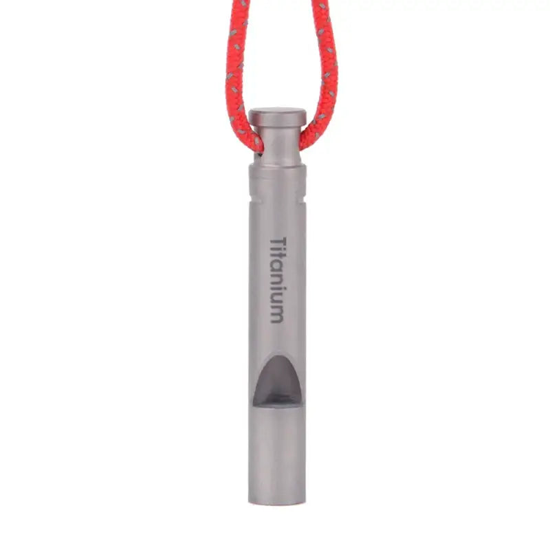 Metallic whistle with ’Titanium’ engraved on it, suspended by a red cord.