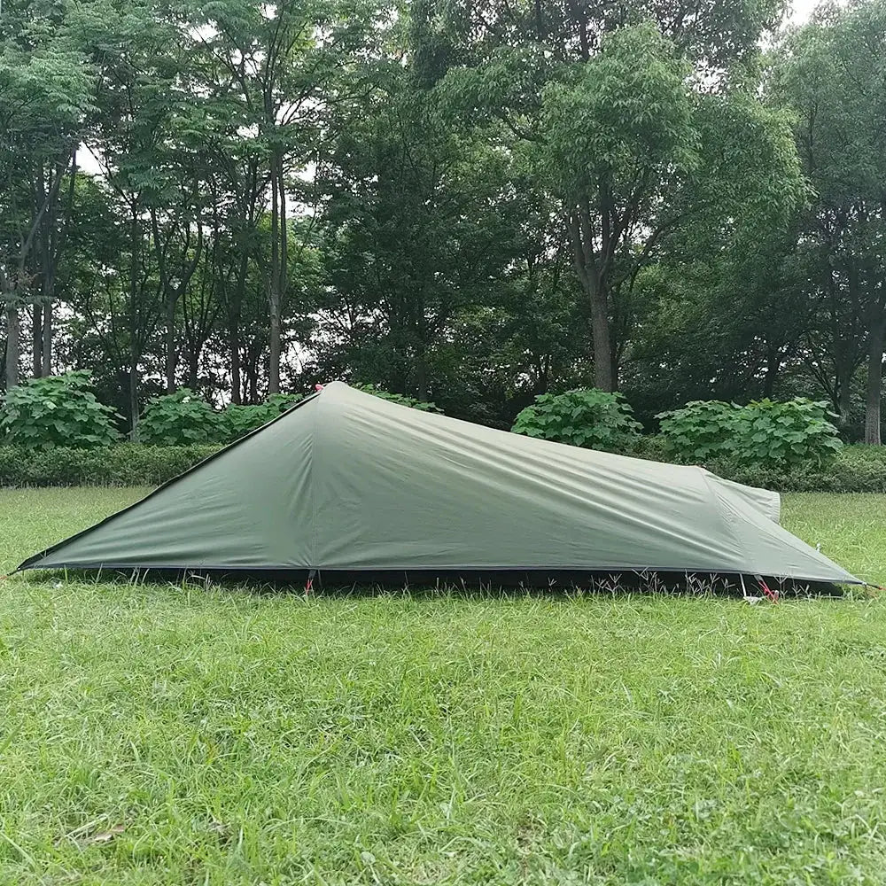 Green camping tent pitched on grass.