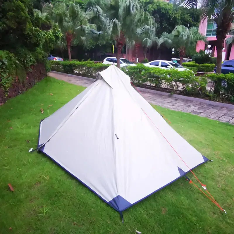 White camping tent pitched on grass.