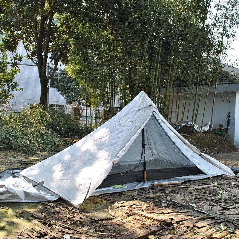 White tent pitched in an outdoor setting.