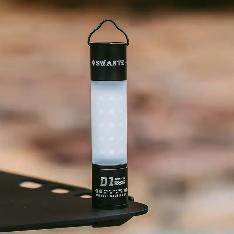 Portable LED camping lantern with a cylindrical design and carrying handle.