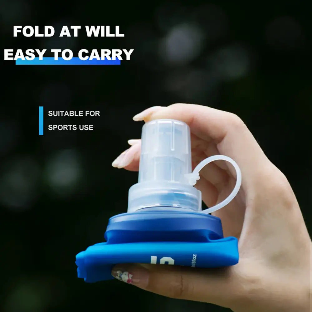 Collapsible water bottle with a blue base and white foldable body held in a hand.